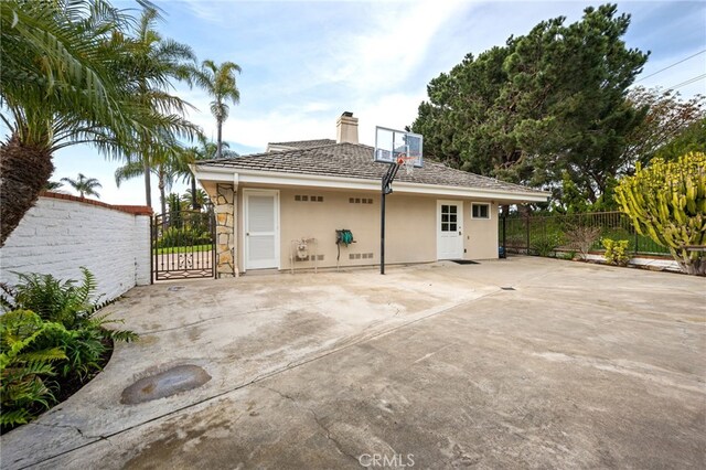 4 Huntington Ct, Newport Beach, CA 92660 - rear view of house featuring a gate, stucco siding, and a chimney