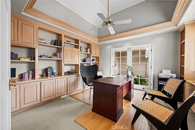 office area featuring crown molding, ceiling fan, a tray ceiling, lofted ceiling, and light wood-style flooring