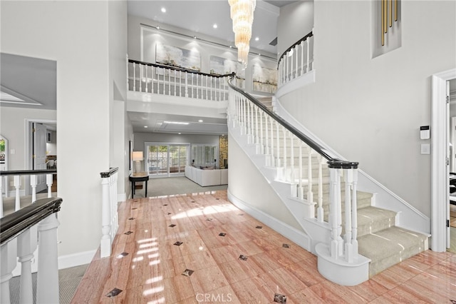 foyer featuring recessed lighting, stairway, baseboards, and a towering ceiling