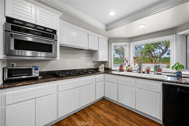 kitchen featuring dark wood finished floors, a sink, oven, black dishwasher, and crown molding