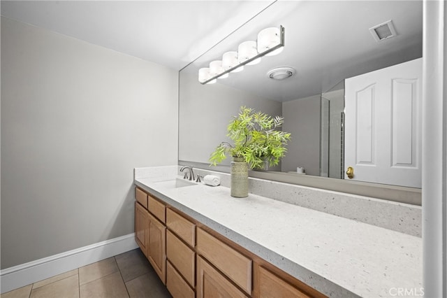 bathroom with tile patterned floors, visible vents, a shower with door, baseboards, and vanity