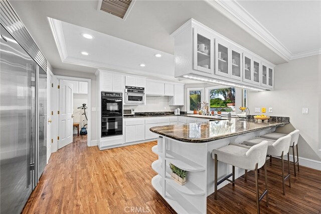 4 Huntington Ct, Newport Beach, CA 92660 - kitchen with ornamental molding, stainless steel appliances, a peninsula, recessed lighting, and white cabinetry