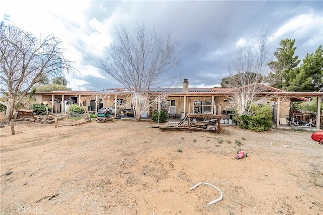 rear view of property with a chimney and a deck