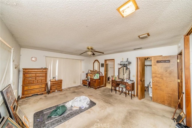 bedroom featuring a textured ceiling, visible vents, and a ceiling fan