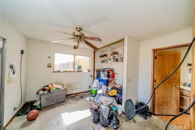 interior space featuring a ceiling fan, a textured ceiling, and unfinished concrete floors