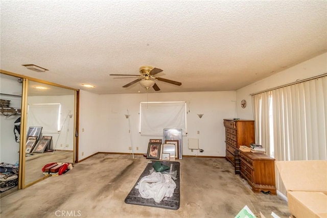 interior space with a ceiling fan, light carpet, a textured ceiling, and baseboards