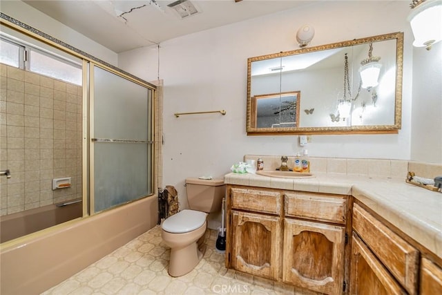 bathroom featuring visible vents, toilet, combined bath / shower with glass door, vanity, and tile patterned floors