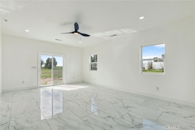 empty room with a healthy amount of sunlight, marble finish floor, and baseboards