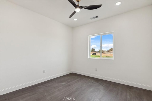 spare room featuring dark wood-style floors, recessed lighting, visible vents, and baseboards
