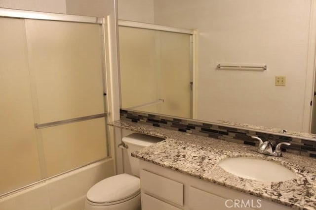 full bathroom with toilet, shower / bath combination with glass door, and vanity