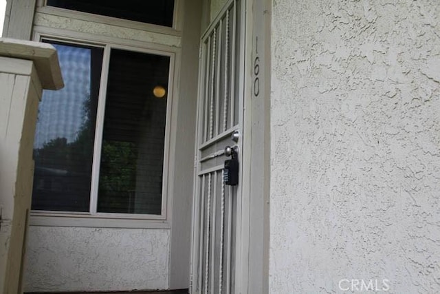 view of exterior entry featuring stucco siding