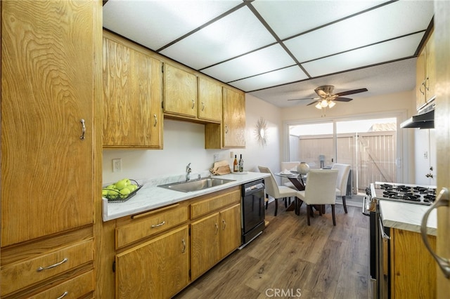 kitchen featuring under cabinet range hood, a sink, black dishwasher, gas stove, and light countertops