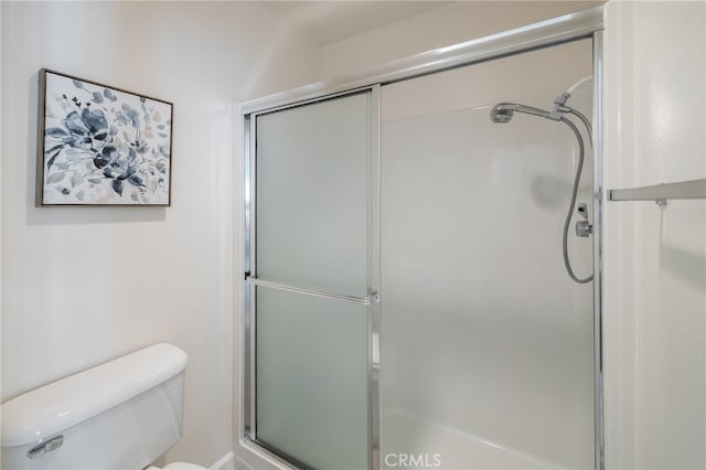 full bathroom featuring a shower with door and toilet