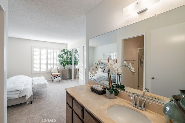 bathroom with vanity, a textured ceiling, and ensuite bathroom