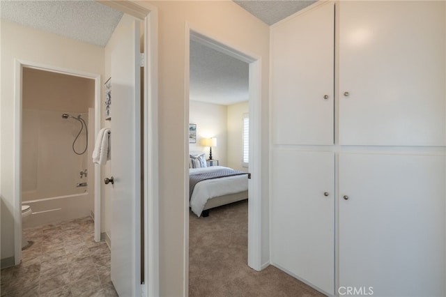 corridor featuring light colored carpet and a textured ceiling