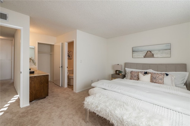 bedroom with baseboards, visible vents, a closet, a textured ceiling, and light carpet