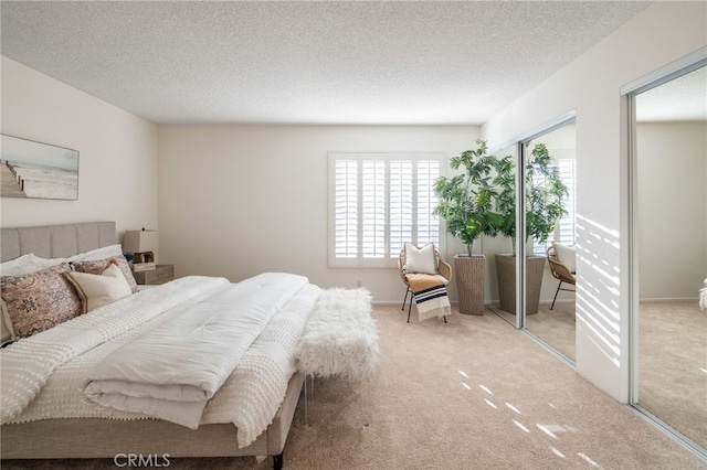 carpeted bedroom with a textured ceiling and baseboards