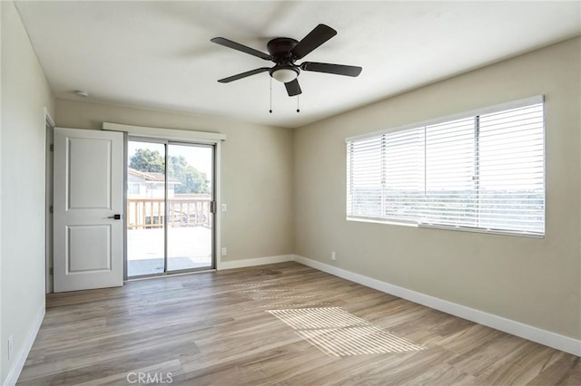 empty room featuring ceiling fan, light wood-style floors, and baseboards