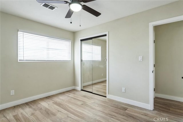 unfurnished bedroom with light wood-style floors, baseboards, visible vents, and a closet