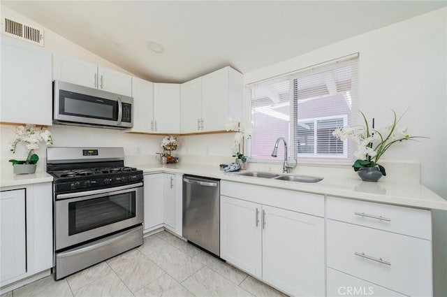 kitchen with stainless steel appliances, light countertops, visible vents, white cabinets, and a sink