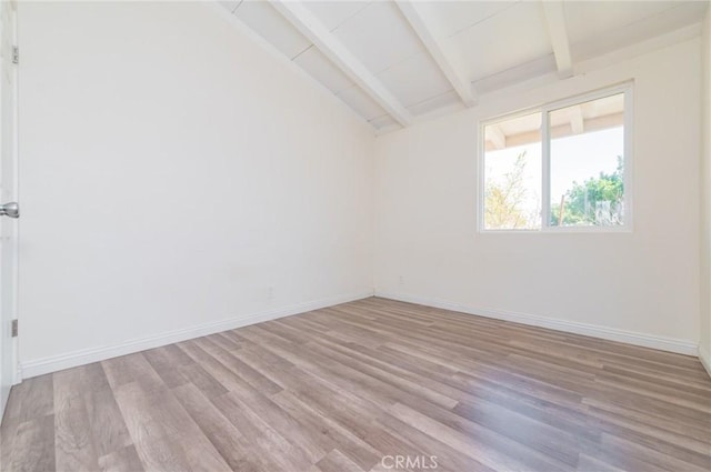 empty room with vaulted ceiling with beams, light wood-style floors, and baseboards