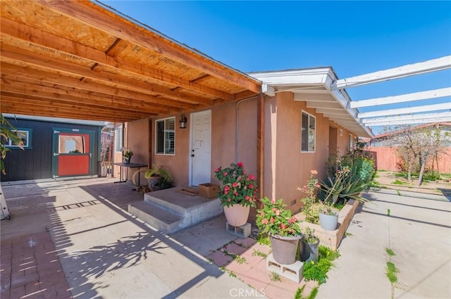 doorway to property featuring a patio area and stucco siding