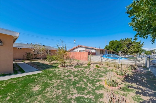 view of yard featuring fence and a fenced in pool