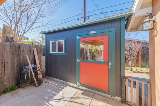 view of outbuilding with fence and an outdoor structure