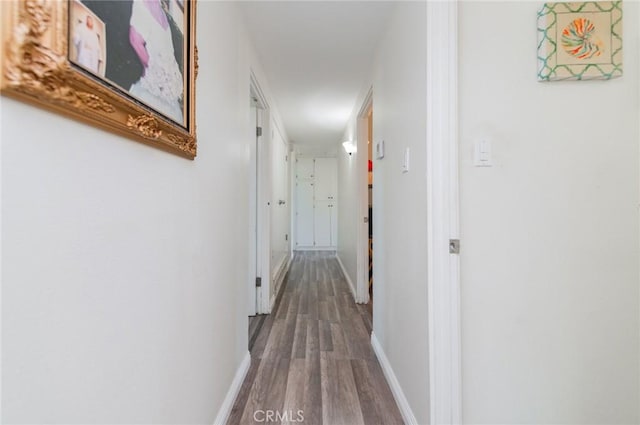 hall featuring baseboards and wood finished floors