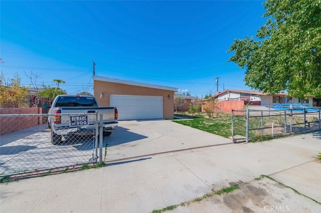 exterior space featuring a garage, fence, and stucco siding