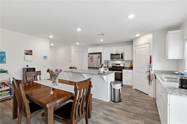 dining room with light wood-style floors, recessed lighting, and visible vents