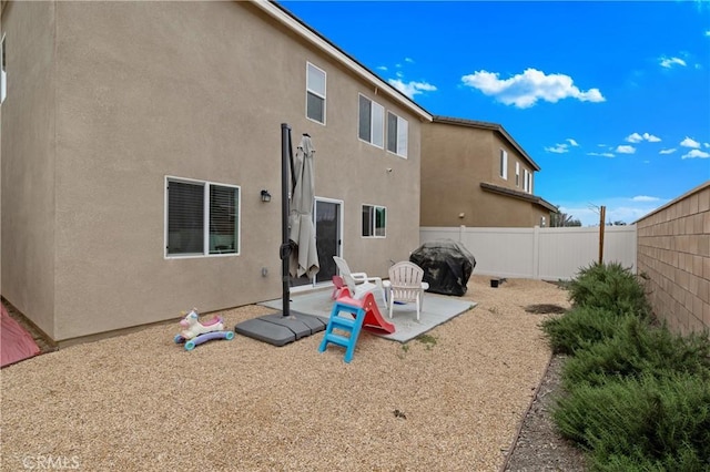 back of property with a patio area, a fenced backyard, and stucco siding