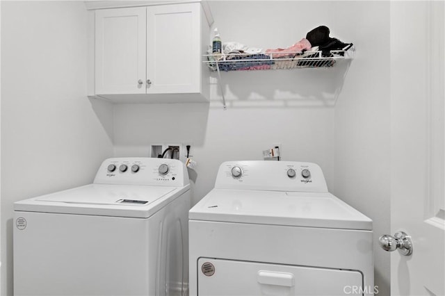 washroom with washer and clothes dryer and cabinet space