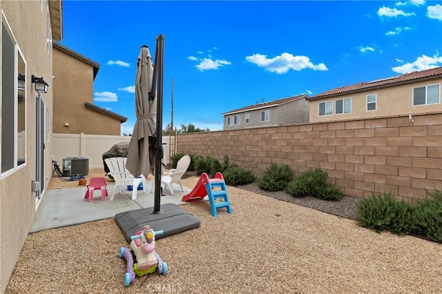 view of jungle gym featuring a fenced backyard, central AC, and a patio