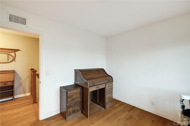 interior space featuring light wood-type flooring, visible vents, and baseboards