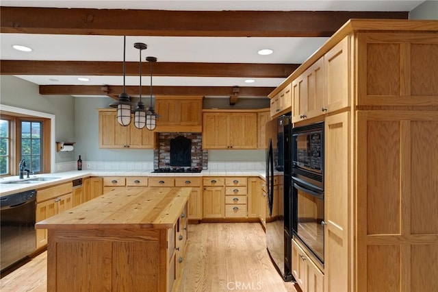 kitchen with light wood-style flooring, a sink, butcher block countertops, beamed ceiling, and black appliances