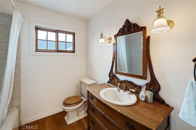 bathroom featuring baseboards, toilet, wood finished floors, shower / bathtub combination with curtain, and vanity