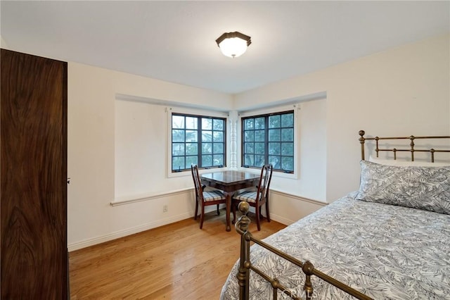 bedroom with light wood finished floors and baseboards