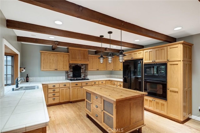 kitchen with black appliances, butcher block countertops, a sink, and light wood-style flooring