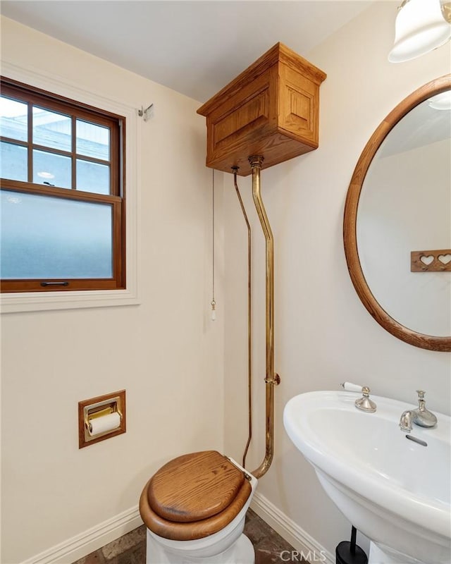 bathroom featuring a sink, toilet, and baseboards