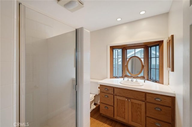 full bathroom featuring a stall shower, wood finished floors, vanity, and recessed lighting