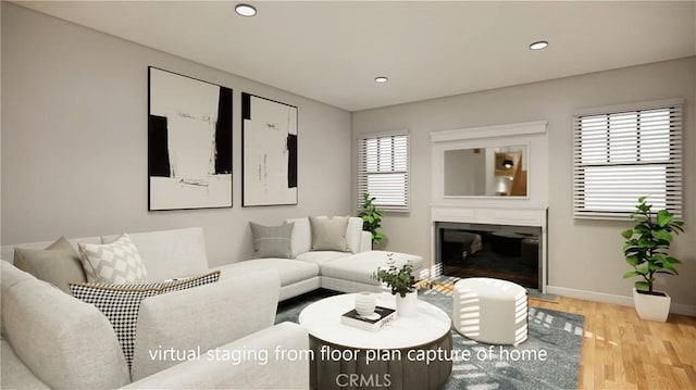 living area with recessed lighting, light wood-style flooring, baseboards, and a glass covered fireplace