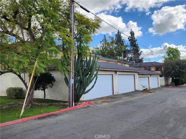 exterior space featuring community garages and stucco siding