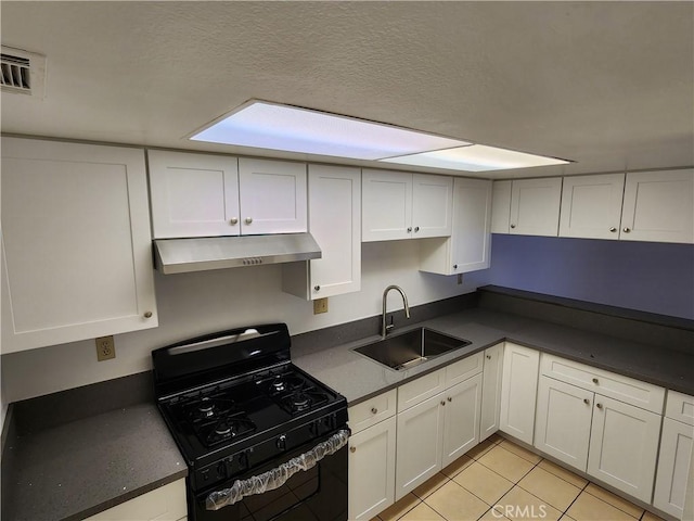 kitchen featuring dark countertops, under cabinet range hood, black range with gas cooktop, and a sink