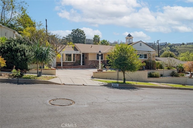 view of front facade featuring driveway and fence