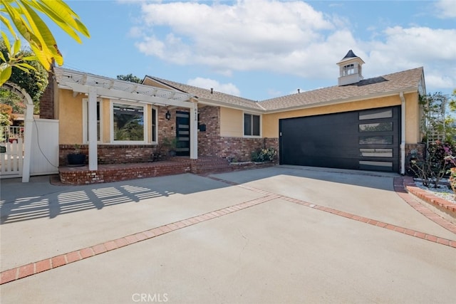 single story home with an attached garage, stucco siding, concrete driveway, and brick siding