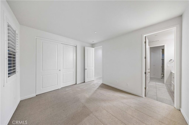 unfurnished bedroom with a closet, carpet, and baseboards