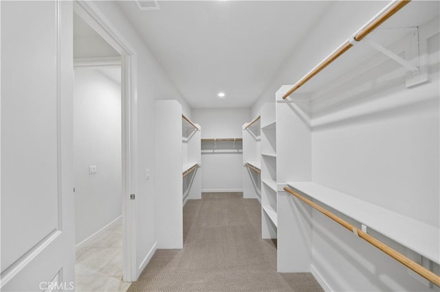 spacious closet with visible vents and light colored carpet