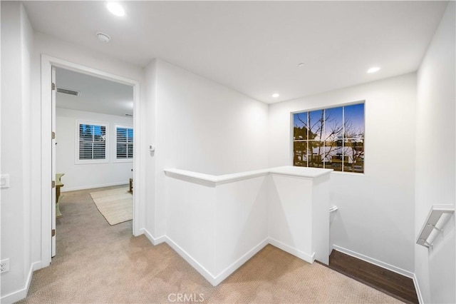 hall with recessed lighting, carpet floors, visible vents, baseboards, and an upstairs landing