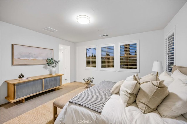 carpeted bedroom with visible vents and baseboards